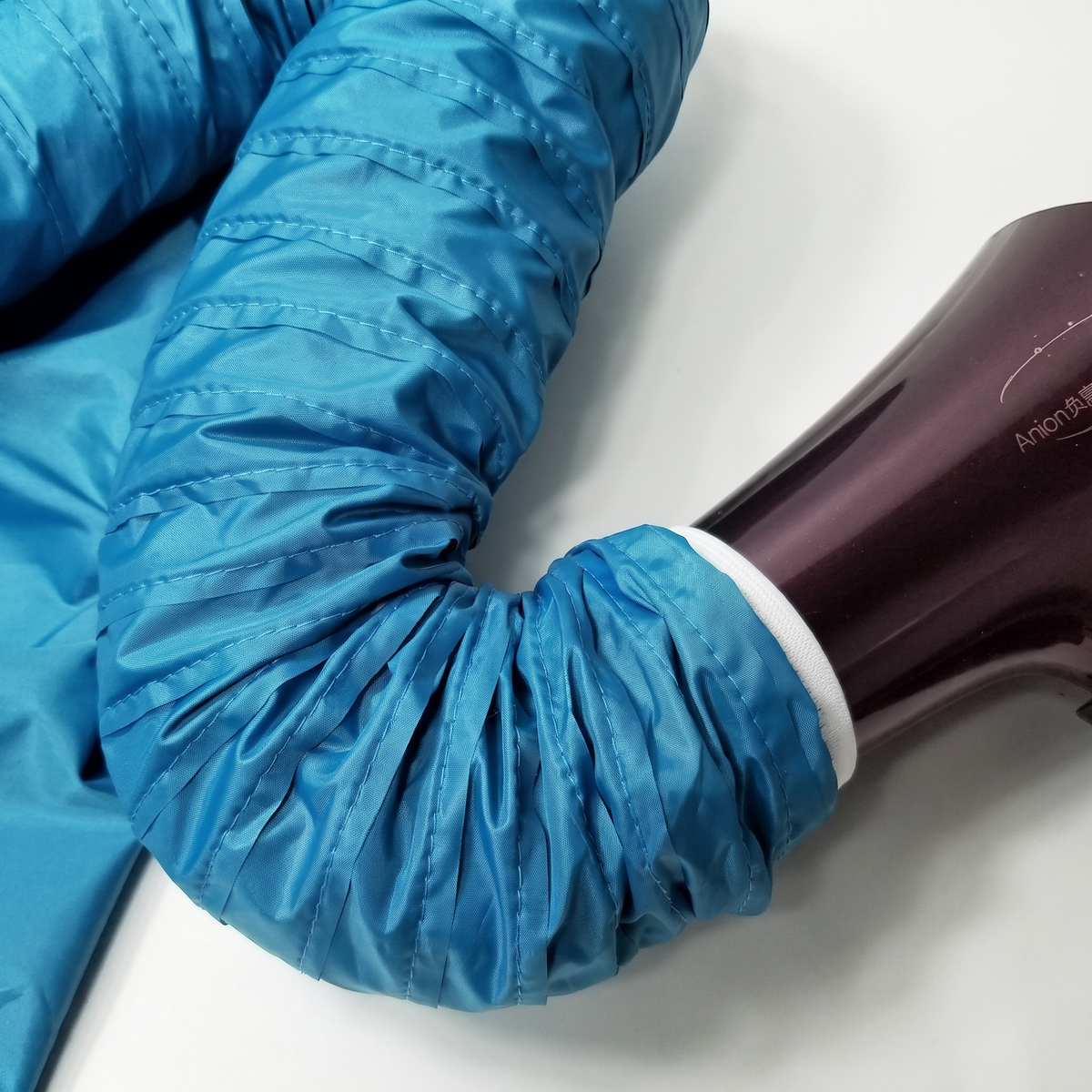 Close-up of the fabric hose with its white elastic cuff connected to a hair dryer